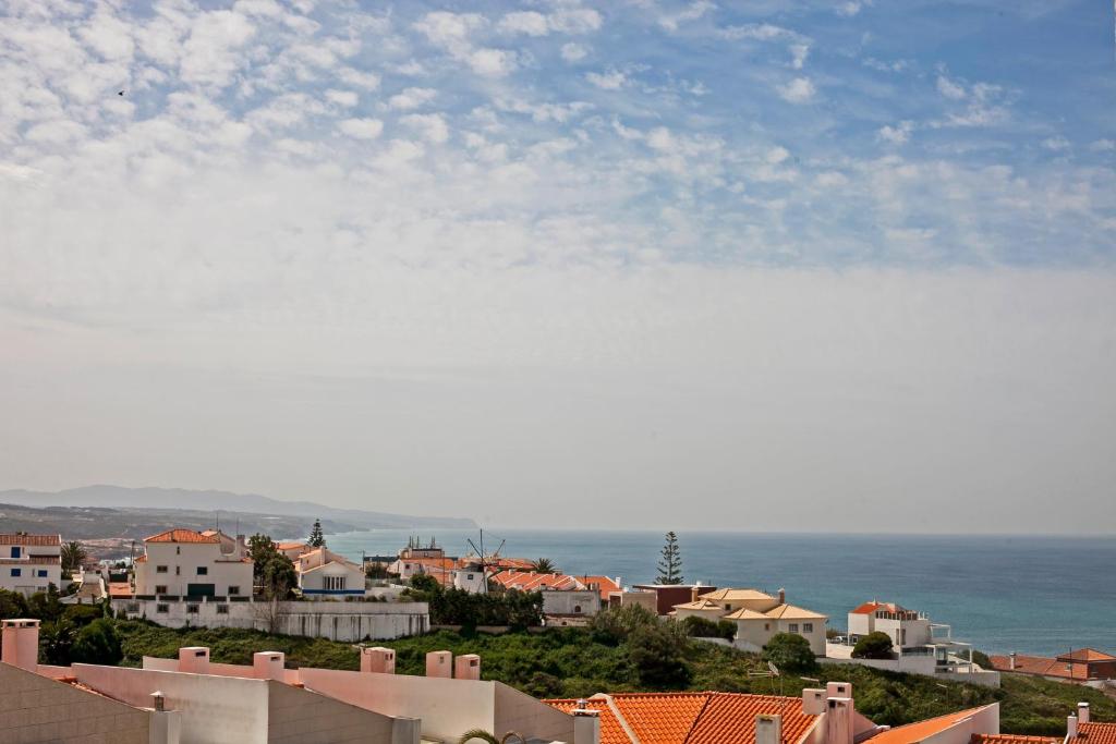a view of a city with houses and the ocean at Ericeira Chill Hill Hostel & Private Rooms in Ericeira