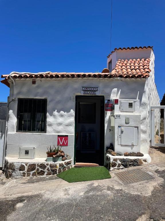 a white house with a black door in front of it at La Puerta del Sol in Adeje