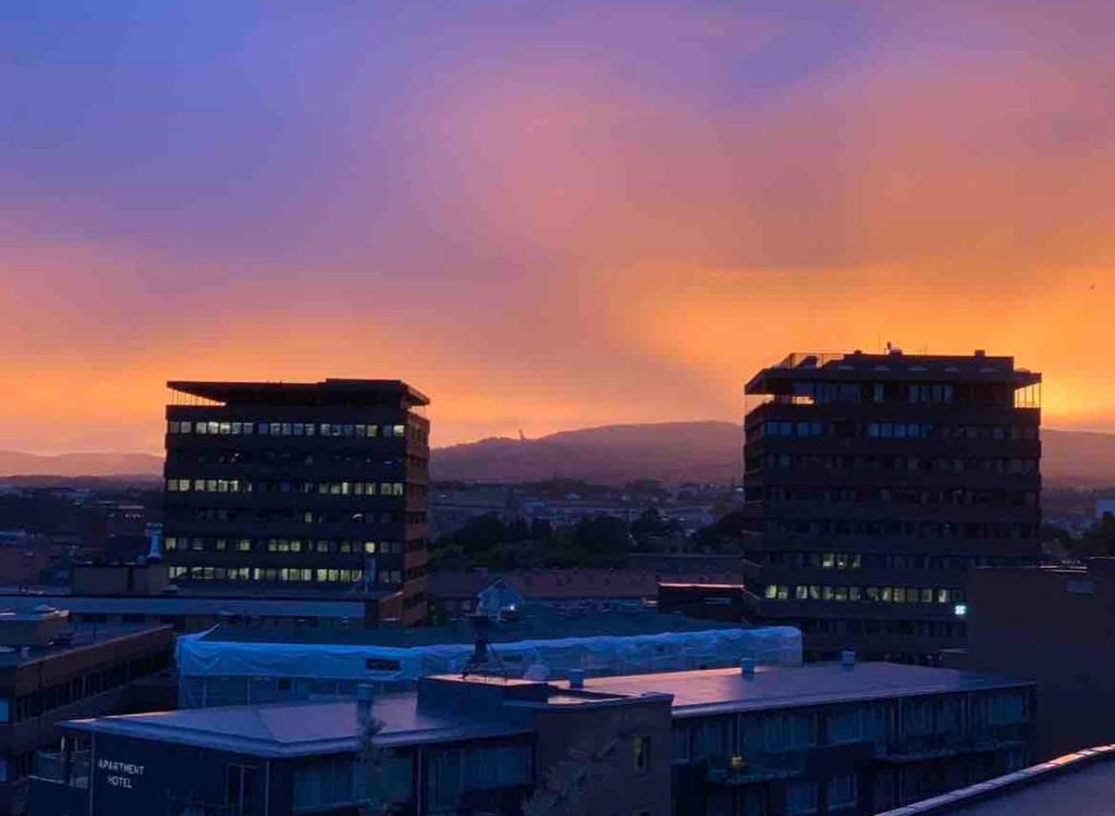 a city skyline with two tall buildings at sunset at Central apartment with an amazing view in Oslo