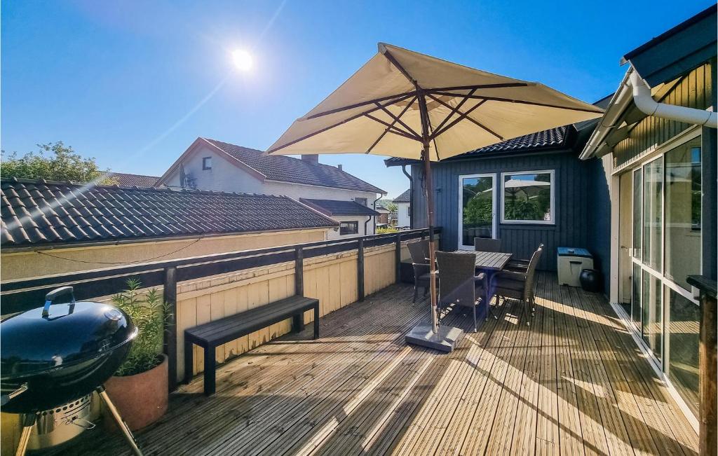 a wooden deck with an umbrella and a grill at Lovely Home In Gteborg With Kitchen in Gothenburg