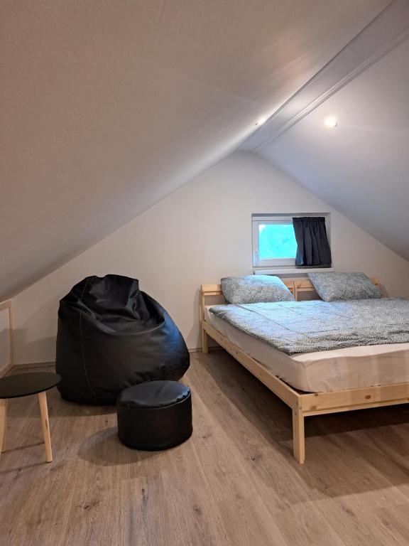 a bedroom with two beds and a bean bag chair at Birs Vendégház Tiszafüred in Tiszafüred