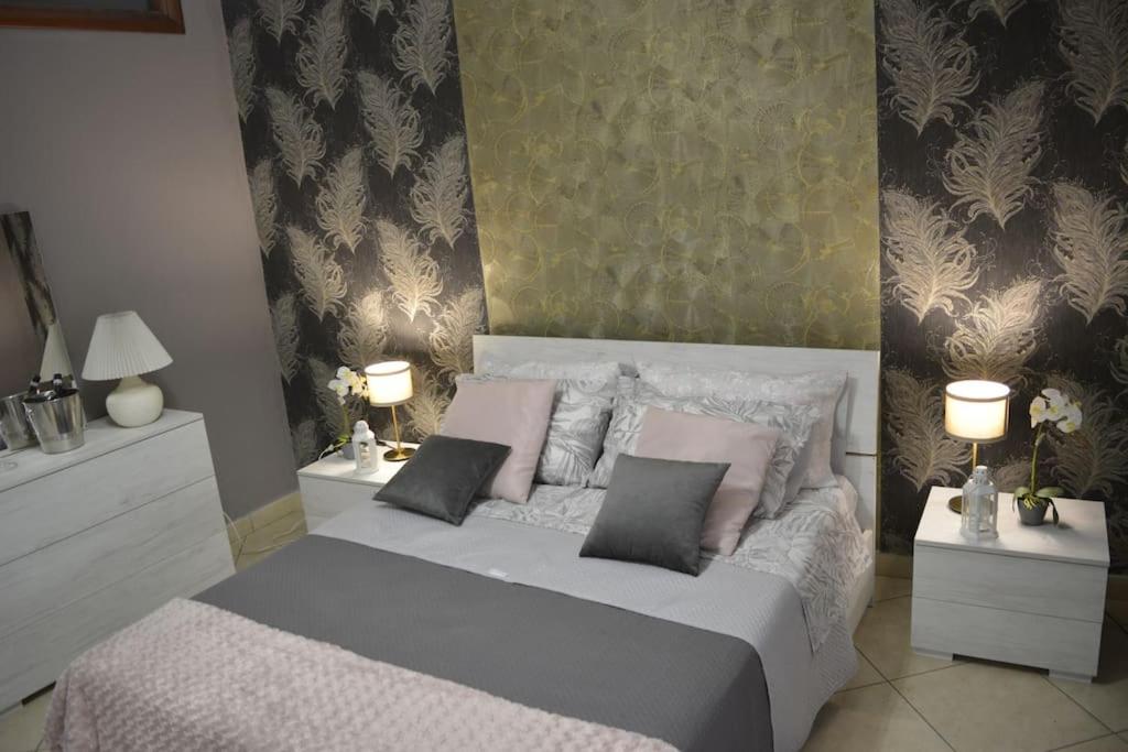 a bedroom with a bed with pink pillows and two lamps at Fedro Domus (Vacanze Pompeiane) in Pompei