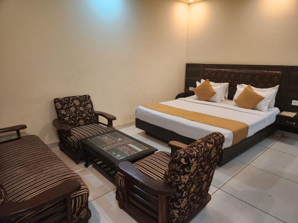 a hotel room with a bed and a chair at Hotel City Lite Near IGI Airport Delhi in New Delhi