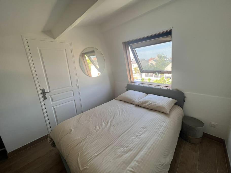 a small bedroom with a bed and a window at Livry07 Paris Aéroport CDG Disneyland Parc des exposition in Livry-Gargan