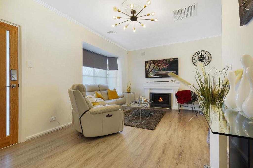a living room with a couch and a fireplace at West Beach House 4U in Henley Beach South