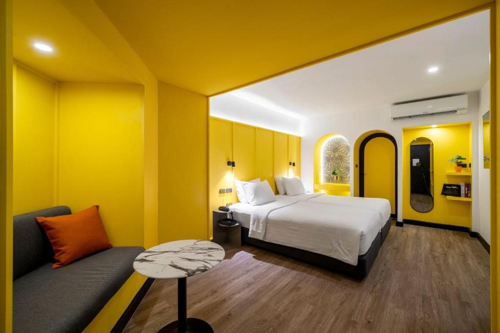 a hotel room with a bed and a couch at Myhotel Cmyk@Ratchada in Bangkok