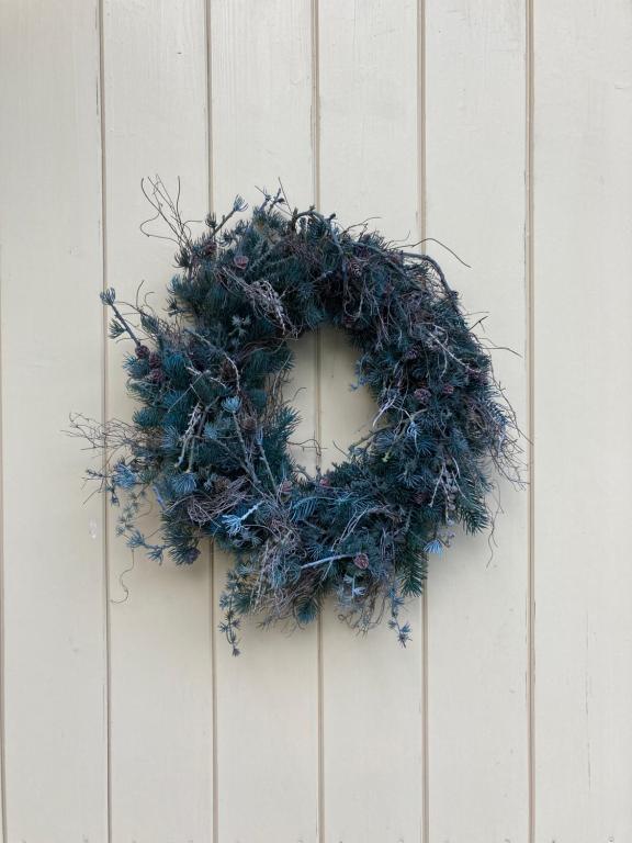 a dark blue wreath on a white door at Familienchalets am Millstätter See in Rothenthurn