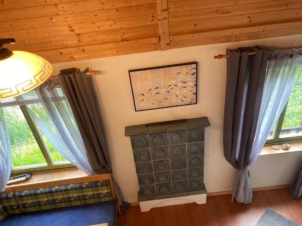a room with two windows and a picture on the wall at Familienchalets am Millstätter See in Rothenthurn