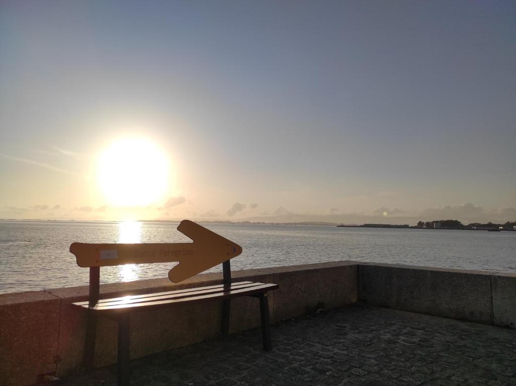 ein Pfeilschild auf einer Bank vor dem Wasser in der Unterkunft Fogar San Sadurniño in Cambados