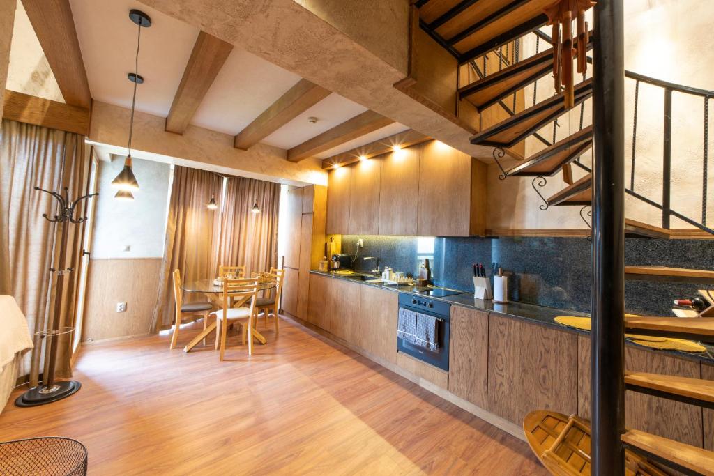 una cocina con armarios de madera, mesa y sillas en Pirin Golf&Spa Apartment 42, en Razlog