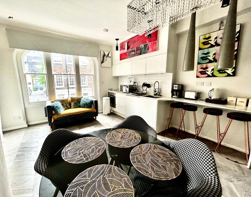 een woonkamer met een aantal stoelen en een keuken bij soho london suite in Londen