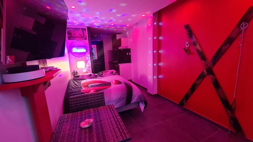 a pink bedroom with a bed with pink lighting at Phantasme Naturiste Studio Terrasse Port Nature in Cap d'Agde
