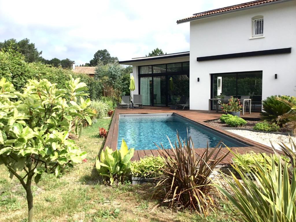 una piscina en el patio trasero de una casa en La villa du golf en Gujan-Mestras