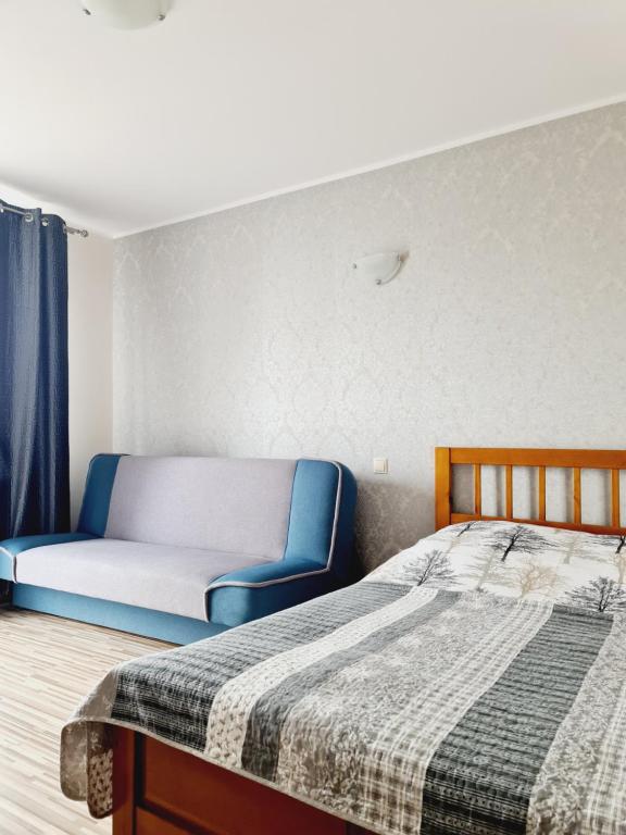 弗瓦迪斯瓦沃沃的住宿－Dom Wczasowy Zamorski，一间卧室配有一张床和一张蓝色椅子