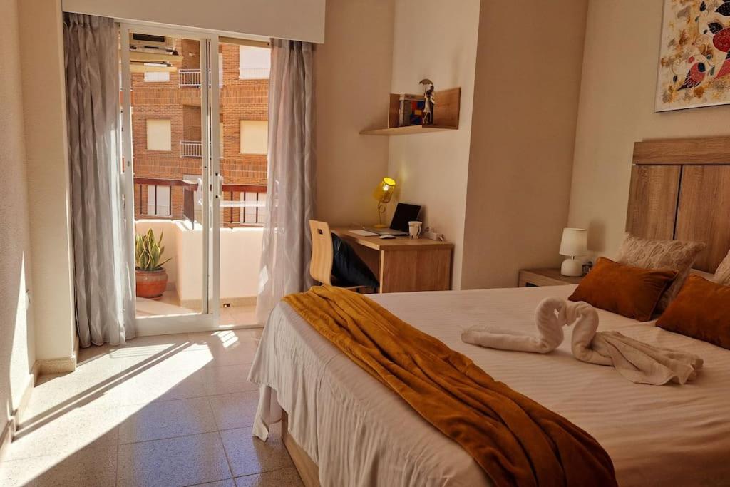 une chambre avec un lit, une fenêtre et un bureau dans l'établissement Jardin playa del cura apartment, à Torrevieja