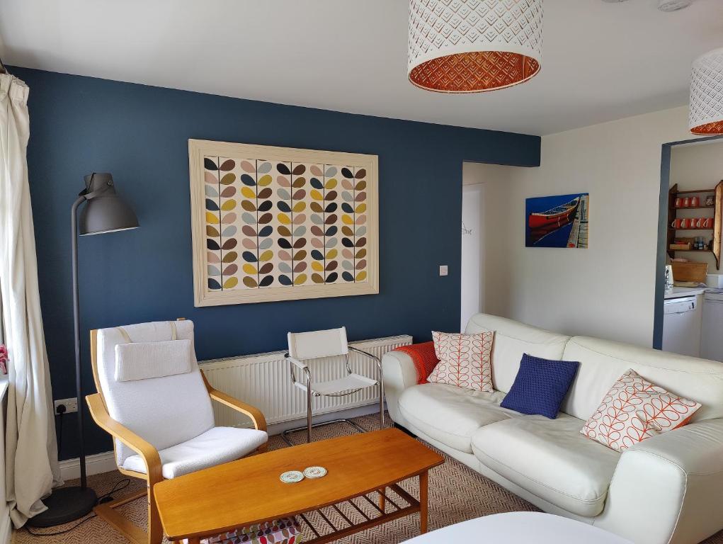 a living room with a couch and two chairs at Crow's Nest Glandore - 3 - Self Catering in Glandore