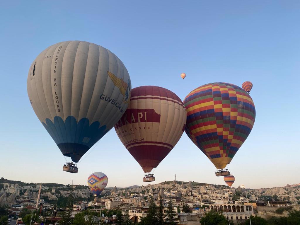 drei Heißluftballons fliegen über eine Stadt in der Unterkunft Cappadocia Kepez hotel in Goreme