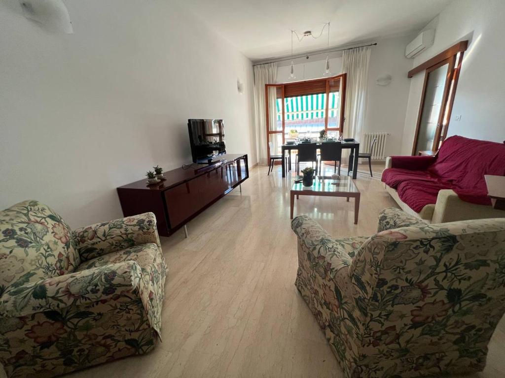 uma sala de estar com duas cadeiras, um sofá e uma mesa em A casa di Nonna em Pescara