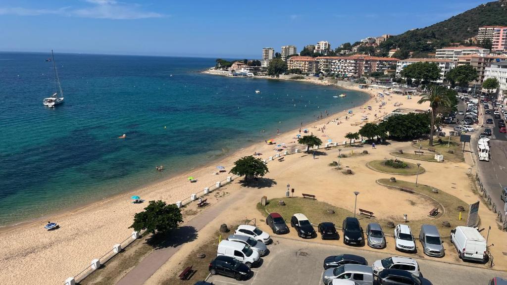 plaża z kilkoma samochodami zaparkowanymi obok wody w obiekcie Le Face à La Mer w Ajaccio
