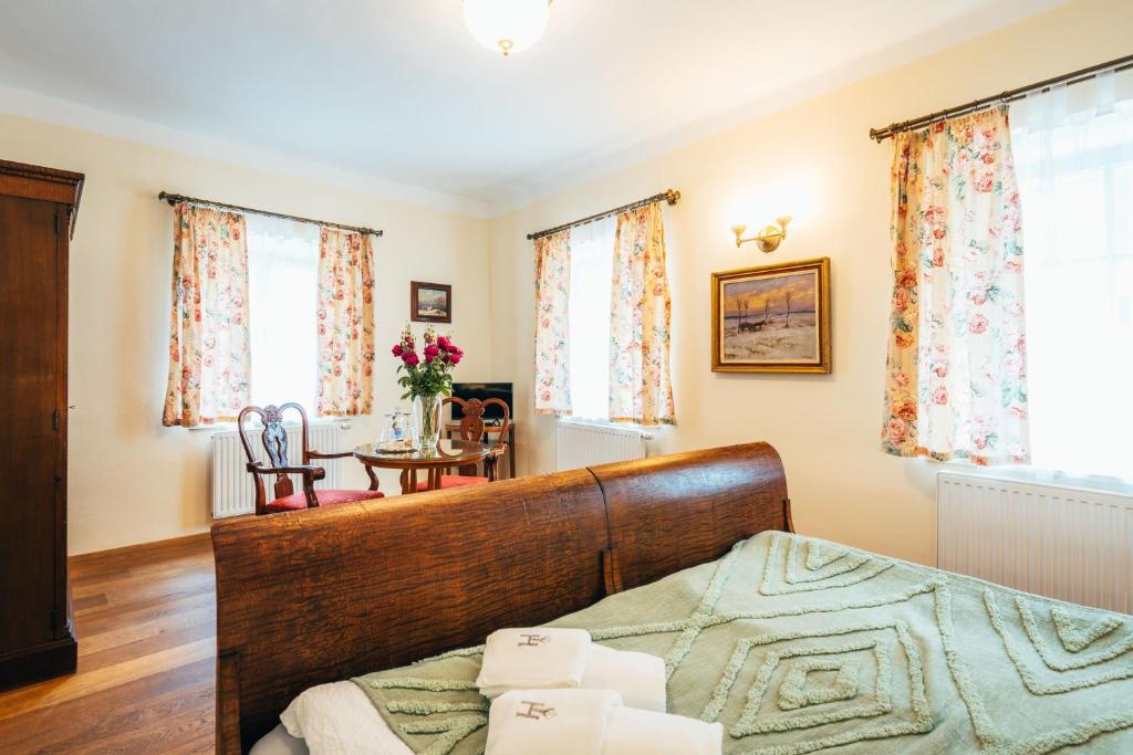 a bedroom with a bed and a table and windows at Sv. Hubertus in Český Krumlov