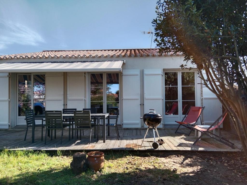 una casa con parrilla y sillas en una terraza en Location maison à l'Epine sur Île de Noirmoutier, en LʼÉpine