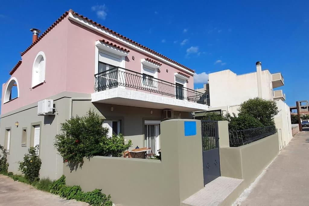 une maison rose et blanche avec une clôture blanche dans l'établissement Tranquility Base, à Néapolis