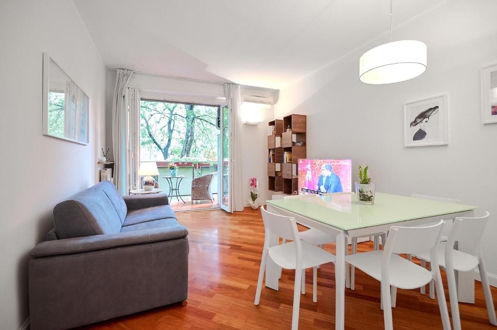 uma sala de estar com uma mesa e cadeiras e um sofá em MiCo GARDEN VIEW CITYLIFE EXECUTIVE APARTMENT em Milão