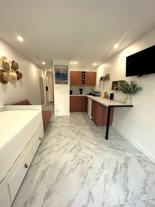 une grande cuisine avec un grand sol en marbre blanc dans l'établissement Le Massilhan - à 100M de la mer, à Le Castellas