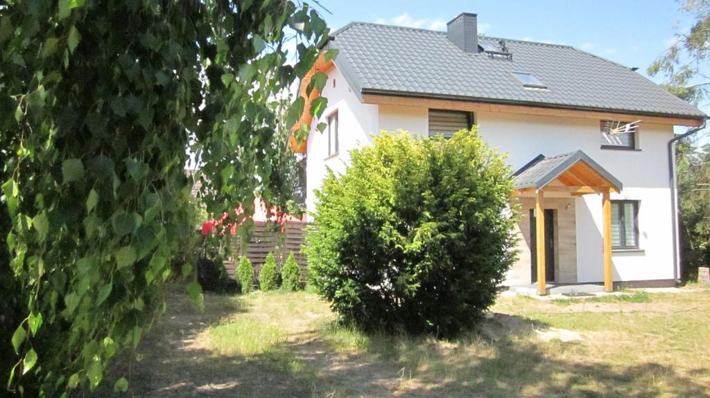 una casa blanca con un arbusto delante de ella en Dom Letniskowy Zuzanna, en Nadole