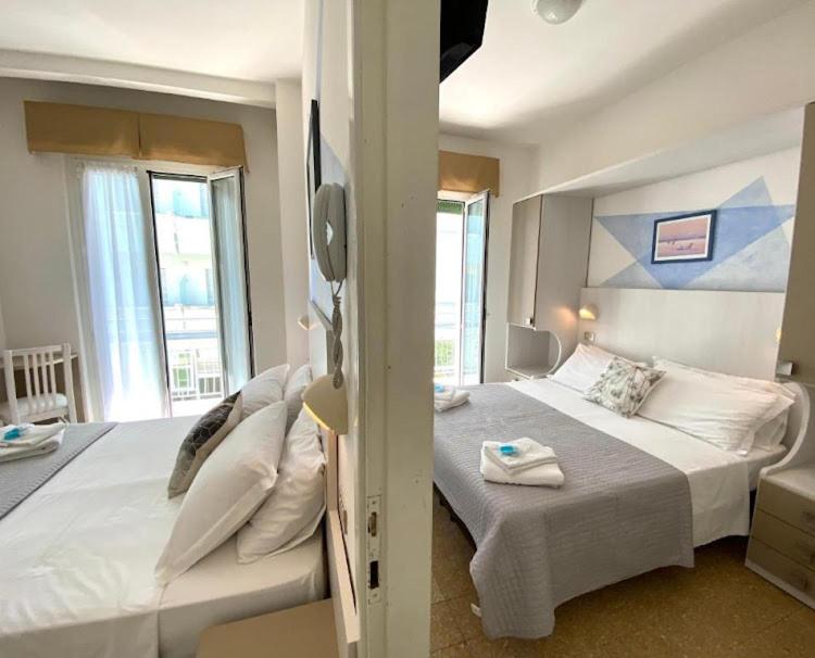 una camera da letto con un grande letto con asciugamani di Alevon Hotel a Rimini