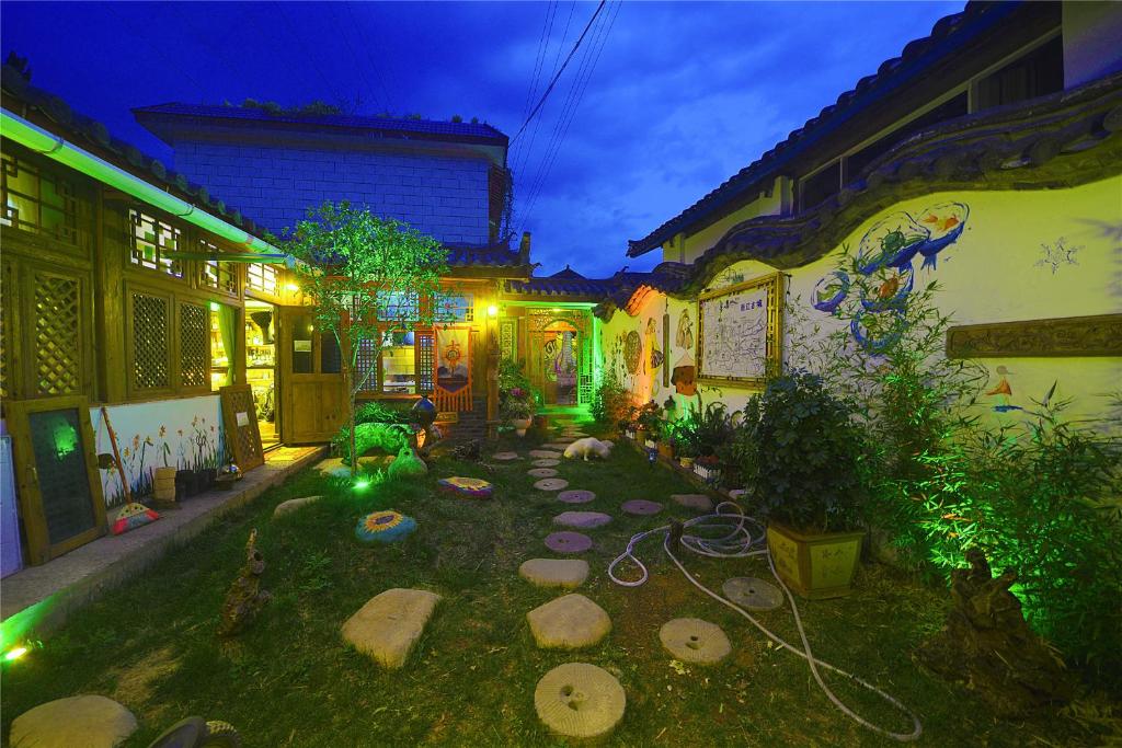 einen Garten mit Felsen im Hof nachts in der Unterkunft October Inn in Lijiang