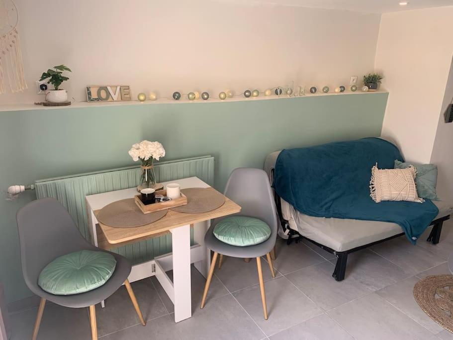 Habitación con mesa, 2 sillas, mesa y banco. en Maison au calme à 25min de Paris, en Dammarie-lès-Lys
