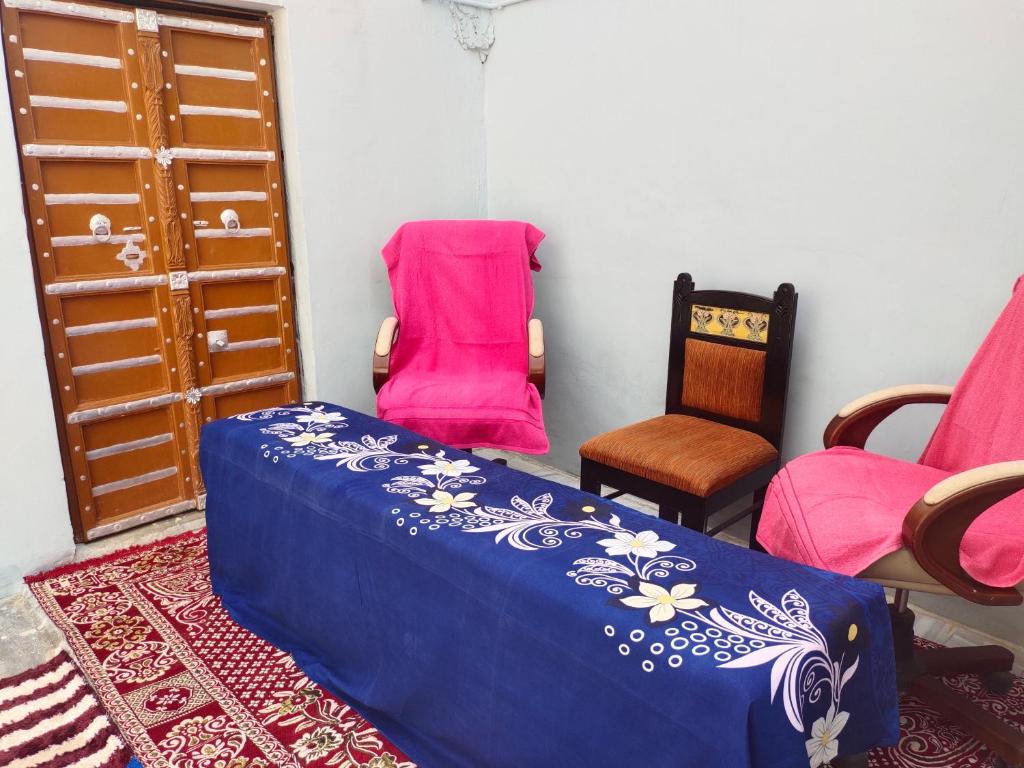 a room with a bed and two chairs and a door at Little prince guest house & homestay in Bikaner