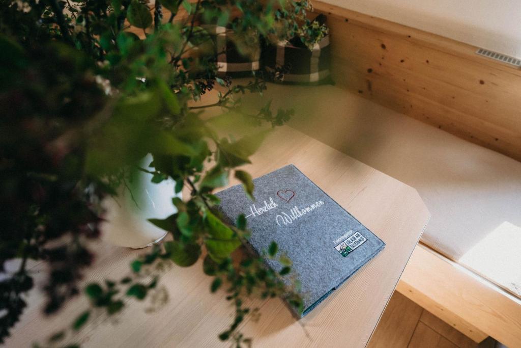 um livro sentado em cima de uma mesa com uma planta em Feichtingerhof em Steinbach am Attersee