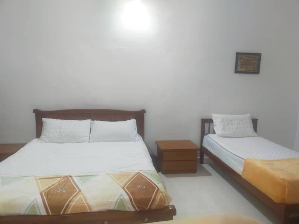 a bedroom with two beds in a room at Rumah Tamu FieSari Jeli M U S L I M in Jeli