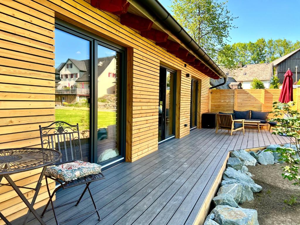 a wooden deck with a table and chairs on it at Lighthouse in Grafengehaig