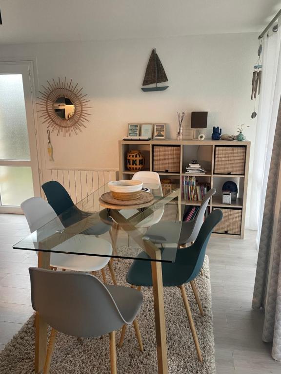 une salle à manger avec une table et des chaises en verre dans l'établissement À deux pas de la plage du Fogeo Arzon, à Arzon