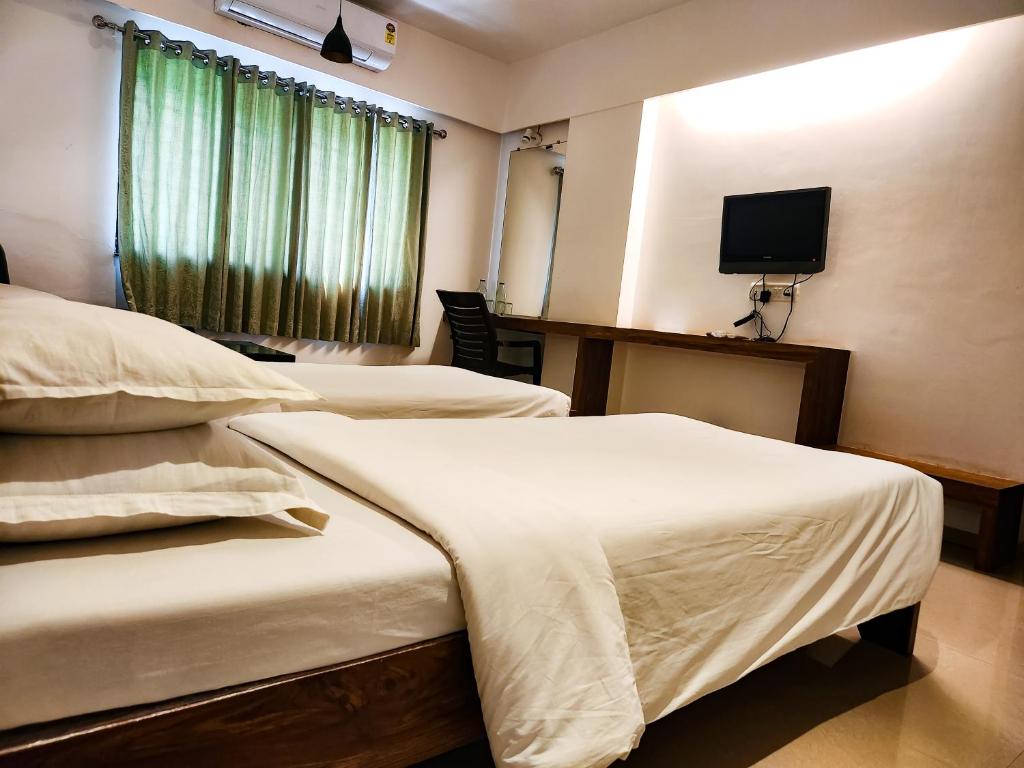 Postel nebo postele na pokoji v ubytování Hotel Rajwada Aurangabad