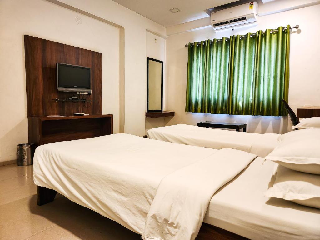 Postel nebo postele na pokoji v ubytování Hotel Rajwada Aurangabad