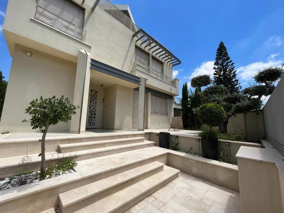 a white house with stairs in front of it at Kosher Luxury villa - Raanana in Ra‘ananna