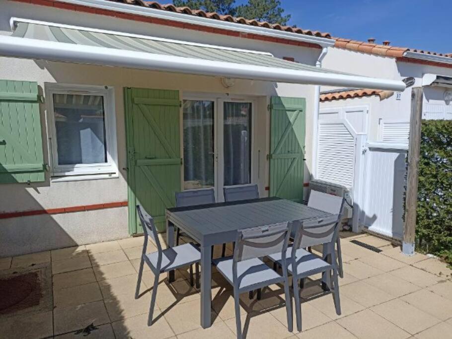 een tafel en stoelen voor een huis bij Maison de vacances 4 personnes in La Tranche-sur-Mer