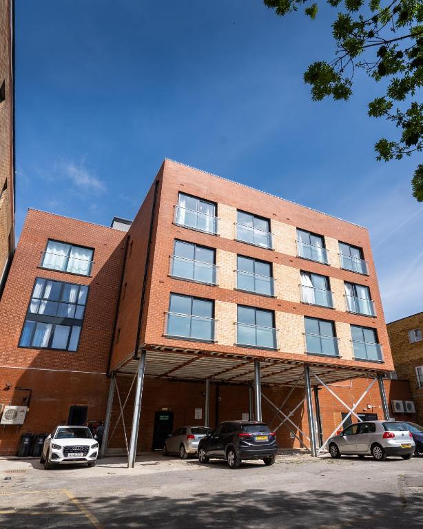a brick building with cars parked in a parking lot at Hemel Apartments - Hemel Haven in Hemel Hempstead