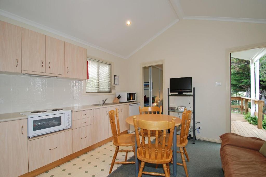 a kitchen with a table and chairs and a couch at Triabunna Cabin & Caravan Park in Triabunna