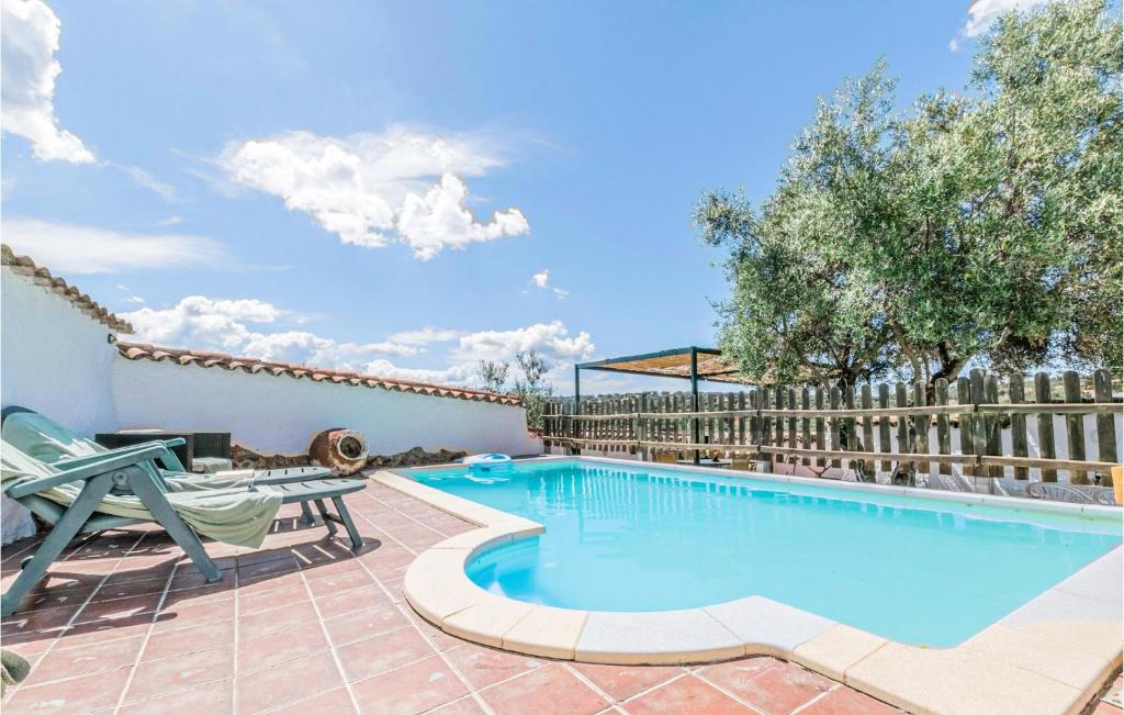 a swimming pool with a table and chairs next to a fence at Cozy Home In La Cardenchosa With Wifi in El Alcornocal