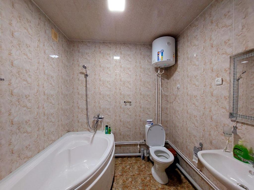 La salle de bains est pourvue d'une baignoire, de toilettes et d'un lavabo. dans l'établissement NUKUS GUEST HOUSE, à Noukous