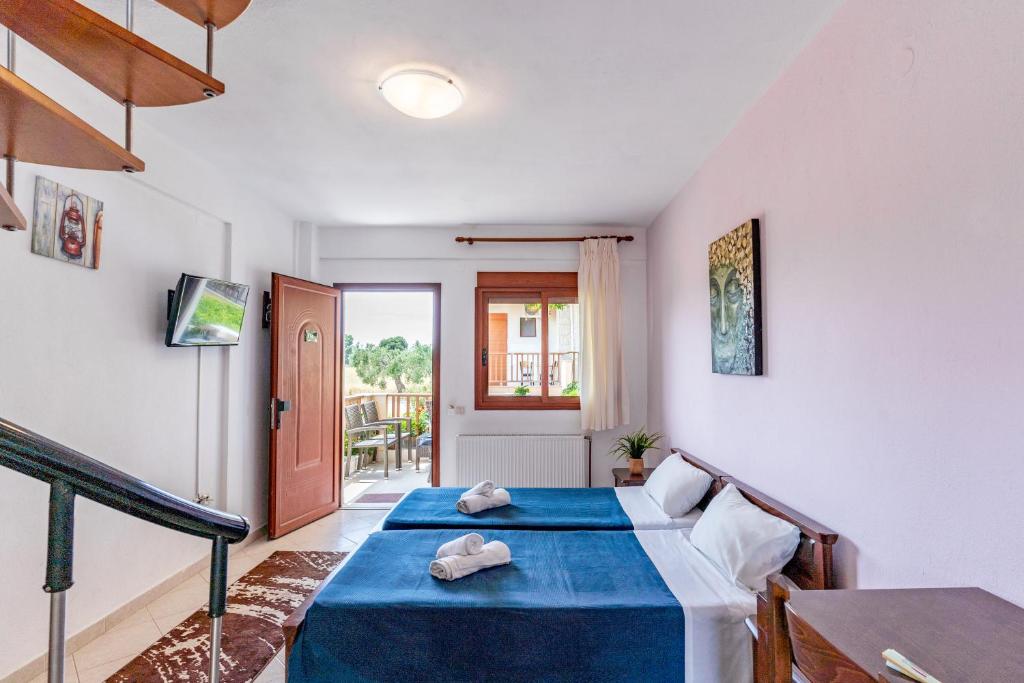 1 dormitorio con 1 cama azul y 1 sofá en Erifili House, en Kallithea Halkidikis