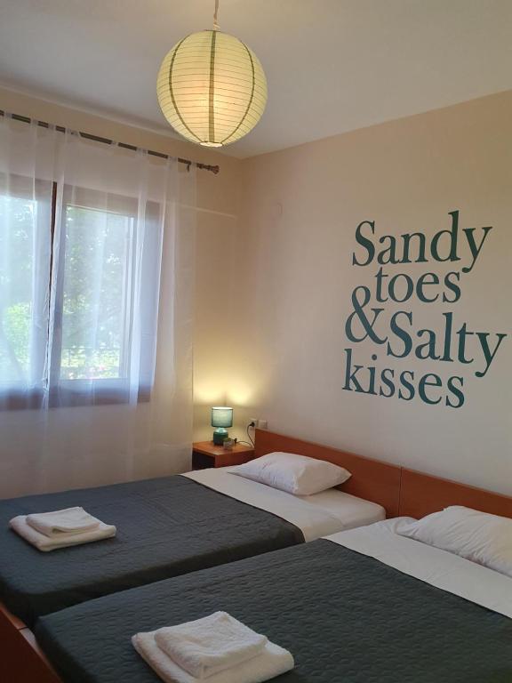 a bedroom with two beds and a sign on the wall at Villa Magnolia in Litochoro