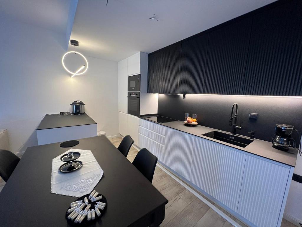 a kitchen with a table and a black and white kitchen at Modern, City/Industrial Style in Ferizaj