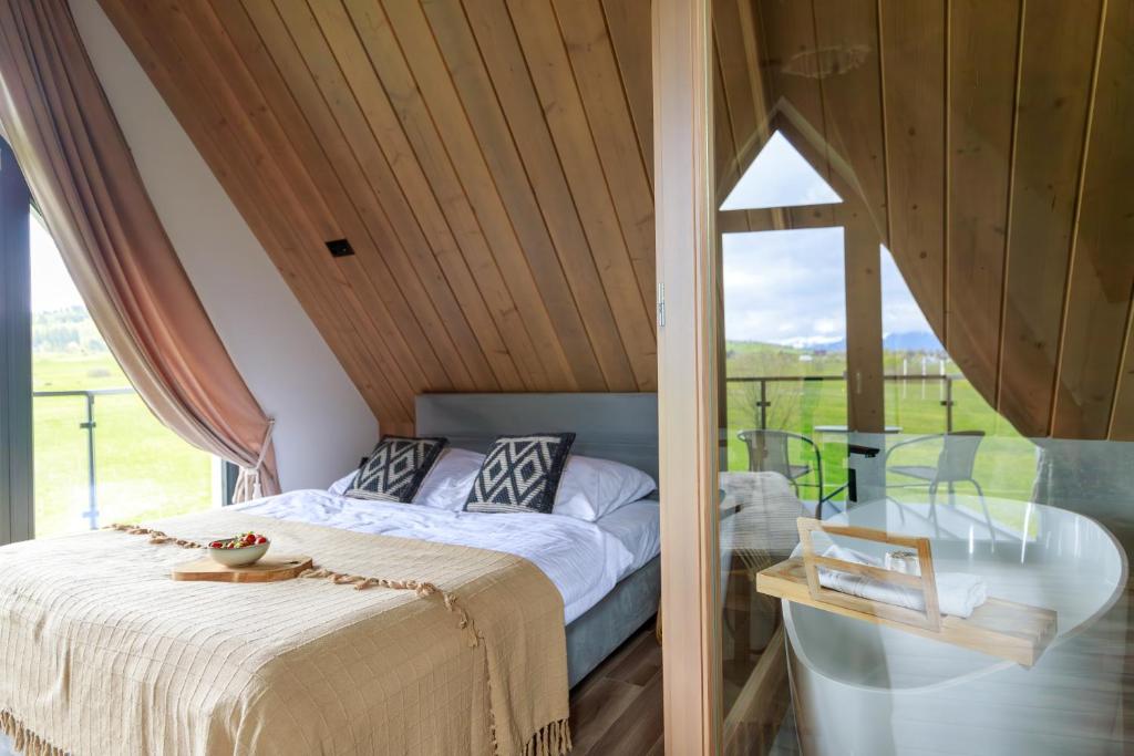 a bedroom with a bed and a glass table at Hill House Apartamenty in Białka Tatrzanska