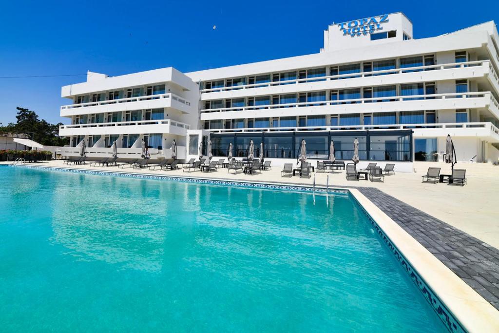 a hotel with a swimming pool in front of a building at HOTEL TOPAZ 4* CAP AURORA in Cap Aurora